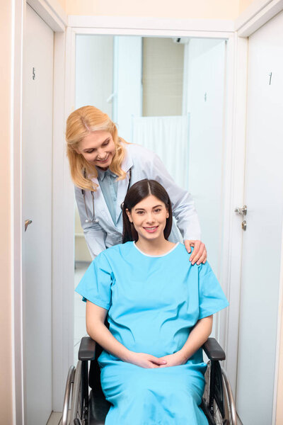 Free: Obstetrician gynecologist riding pregnant woman on wheelchair at ...
